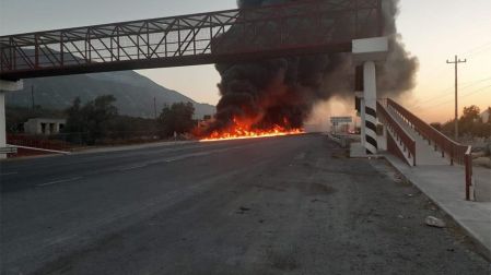 Impactante imagen de una pipa volcada e incendiada frente a gasolinera