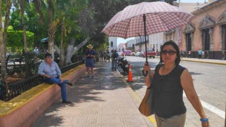Personas se cubren del sol en Mérida, Yucatán