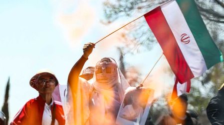 Una mujer iraní ondea la bandera de su país.