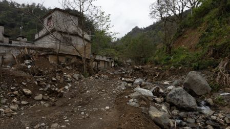 Calle afectada en Chapula, Tianguistengo, Hidalgo, con viviendas dañadas, lodo y rocas tras el paso del huracán Priscila que impactó la comunidad
