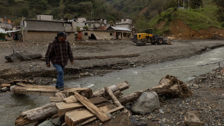 Habitante cruza un río sobre un paso improvisado en Chapula, Tianguistengo, Hidalgo, tras daños del huracán Priscila que afectaron caminos e infraestructura local
