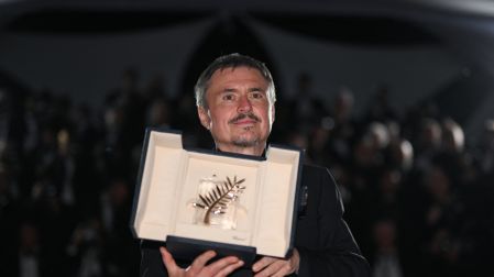 Romanian director, screenwriter and producer Cristian Mungiu poses with the trophy during a photocall after winning the Palme d'Or for the film "Fjord" during the closing ceremony of the 79th edition of the Cannes Film Festival in Cannes, southern France, on May 23, 2026. (Photo by Olivier CHASSIGNOLE / AFP)