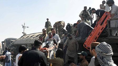 Personas ayudan a heridos tras ataque con bomba a un tren en Pakistán.