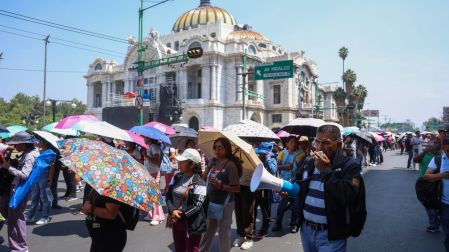 Maestros de la CNTE con sombrillas marchan hacia la Secretaría de Gobernación