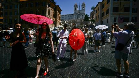 Turistas buscan sombra y agua ante las altas temperaturas en Roma.