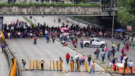 Manifestantes del magisterio bloqueando el tránsito vehicular en Circuito Interior, Ciudad de México, causando intenso tráfico.
