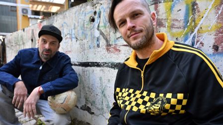 Members of Bosnian Hip-Hop band "Dubioza Kolektiv", Brano Jakubovic (L) and Vedran Mujagic pose with a ball in Sarajevo on June 2, 2026. With brass, guitars, and a music video overflowing with grilled meat, Bosnia has delivered the first World Cup anthem of 2026: "I Am from Bosnia, Take Me to America." the song had already accumulated several million views on different platforms. The song is a cover version of an earlier hit by the Bosnian rock band Dubioza Kolektiv and is rapidly becoming one of the signature songs (anthems) of the 2026 World Cup, which begins on June 11. (Photo by ELVIS BARUKCIC / AFP)