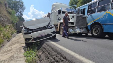 Automóvil compacto blanco con el frente destrozado en la cuneta, a un costado de un tráiler de carga y un autobús azul, tras accidente múltiple en la carretera Apizaco-Tlaxcala.
