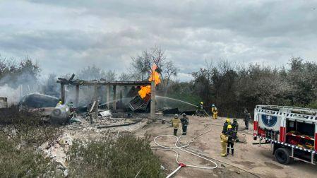 Vista panorámica de un camión de bomberos y elementos de emergencia sofocando las llamas con múltiples mangueras en una bodega clandestina de gas LP colapsada en Tepeaca, Puebla.