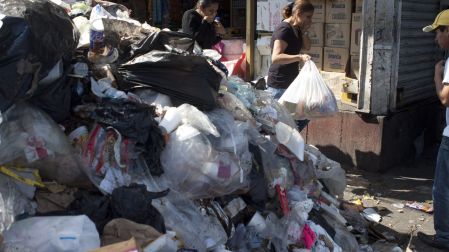 MÉXICO, D.F., 29DICIEMBRE2011.- En la esquina de Rosario y Corregidora en la Candelaria de la delegación Cuauhtémoc se formó un tiradero clandestino que sobrepasaba las 40 toneladas. Los trabajadores del GDF necesitaron varios viajes de camiones de carga para limpiar el basurero a cielo abierto. Mientras los trabajadores laboraban desde temprano en el punto, los vecinos tenían que caminar a pesar del mal olor de los desechos acumulados desde el pasado 23 de diciembre. Los señores de la limpieza señalaron que ciertamente el cierre del bordo poniente a dificultado la limpieza de las calles ya que los camiones recolectores que antes daban de tres a cuatro vueltas hoy solamente hacen uno y también que las personas no separan de forma adecuada la basura.  FOTO: MOISÉS PABLO/CUARTOSCURO.COM