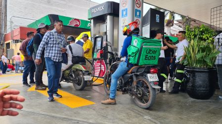 Repartidor de Uber Eats en motocicleta esperando turno para gasolina en estación Pemex tomada por maestros de la CNTE en Tuxtla Gutiérrez.