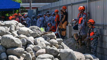 Rescatistas filipinos listos para realizar una búsqueda en edificio colapsado por terremoto 7.8.