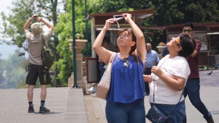 Personas miran un eclipse en calles de México