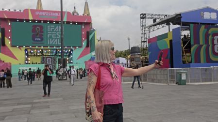 Una mujer se toma una foto en uno de los sitios donde se transmitirán los partidos