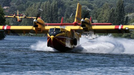 Aviones Canadair CL-415 de la Seguridad Civil francesa realizan maniobras de carga de agua rozando la superficie del río Sena en Chartrettes, en la región parisina de Île-de-France, el 13 de julio de 2026, tras el incendio forestal en el bosque de Fontainebleau.