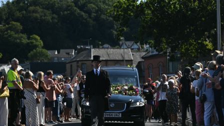 Mourners and fans line the streets to pay their respects as a hearse carrying the coffin of the late singer Bonnie Tyler is driven through her home town of Mumbles, southwest Wales, on August 15, 2026. Welsh singer Bonnie Tyler, best known for her powerful, haunting love song "Total Eclipse of the Heart" died in Portugal on July 8, 2026, aged 75. (Photo by JUSTIN TALLIS / AFP) / Correction - The erroneous mention[s] appearing in the metadata of this photo by JUSTIN TALLIS has been modified in AFP systems in the following manner: [died in Portugal on July 8 2026,] instead of [died in Portugal on August 9, 2026,]. Please immediately remove the erroneous mention[s] from all your online services and delete it (them) from your servers. If you have been authorized by AFP to distribute it (them) to third parties, please ensure that the same actions are carried out by them. Failure to promptly comply with these instructions will entail liability on your part for any continued or post notification usage. Therefore we thank you very much for all your attention and prompt action. We are sorry for the inconvenience this notification may cause and remain at your disposal for any further information you may require.