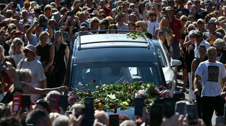 Mourners and fans line the streets to pay their respects as a hearse carrying the coffin of the late singer Bonnie Tyler is driven through her home town of Mumbles, southwest Wales, on August 15, 2026. Welsh singer Bonnie Tyler, best known for her powerful, haunting love song "Total Eclipse of the Heart" died in Portugal on July 8, 2026, aged 75. (Photo by JUSTIN TALLIS / AFP)
