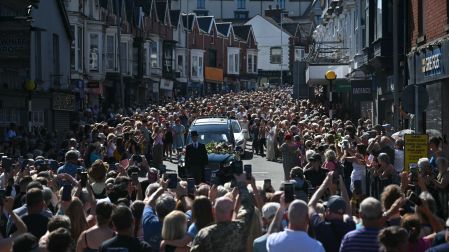 Mourners and fans line the streets to pay their respects as a hearse carrying the coffin of the late singer Bonnie Tyler is driven through her home town of Mumbles, southwest Wales, on August 15, 2026. Welsh singer Bonnie Tyler, best known for her powerful, haunting love song "Total Eclipse of the Heart" died in Portugal on July 8, 2026, aged 75. (Photo by JUSTIN TALLIS / AFP) / Correction - The erroneous mention[s] appearing in the metadata of this photo by JUSTIN TALLIS has been modified in AFP systems in the following manner: [died in Portugal on July 8 2026,] instead of [died in Portugal on August 9, 2026,]. Please immediately remove the erroneous mention[s] from all your online services and delete it (them) from your servers. If you have been authorized by AFP to distribute it (them) to third parties, please ensure that the same actions are carried out by them. Failure to promptly comply with these instructions will entail liability on your part for any continued or post notification usage. Therefore we thank you very much for all your attention and prompt action. We are sorry for the inconvenience this notification may cause and remain at your disposal for any further information you may require.