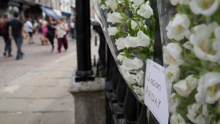 Flores blancas en memoria de Jason Arday junto a las rejas de Senate House, en la Universidad de Cambridge, Reino Unido.