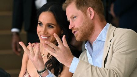 (FILES) Britain's Prince Harry (R), Duke of Sussex, speaks with his wife Meghan Markle while attending a show during a visit to the National Centre for the Arts in Bogota on August 15, 2024. Prince Harry and his wife Meghan, who cut ties with the British royal family in 2020, are moving back to the United Kingdom, British press reported on August 19, 2026. (Photo by RAUL ARBOLEDA / AFP)
