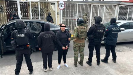 Mujer esposada y custodiada por agentes de la Agencia de Investigación Criminal, Marina y SSPC durante los operativos contra el CJNG.