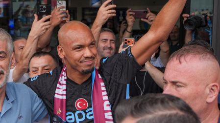 El mediocampista brasileño Fabinho saluda a los aficionados y medios de comunicación a su llegada al aeropuerto de Trebisonda.