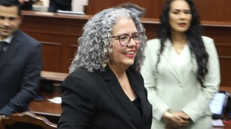 Retrato en primer plano de Graciela Domínguez Nava sonriendo, con su cabello rizado plateado y lentes, tras asumir la gubernatura interina de Sinaloa.