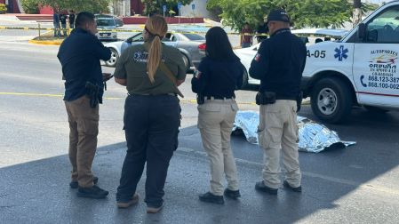 Policías de Tamaulipas al lado del cuerpo de un hombre que se lanzó de un puente