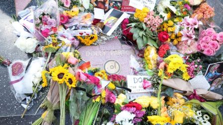 Flores, mensajes y objetos personales comenzaron a llenar la estrella de Dolly Parton.