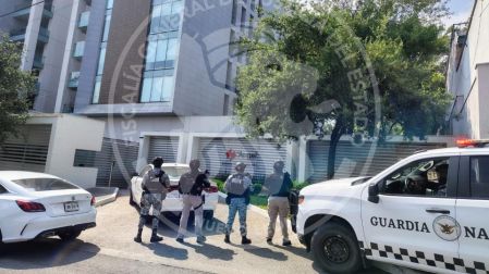 Patrulla de la Guardia Nacional y agentes resguardando el exterior de un edificio en la avenida Roberto Garza Sada, Nuevo León.