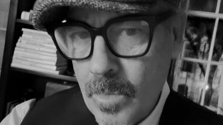 Retrato en blanco y negro de Duncan Sheik con lentes y gorra.