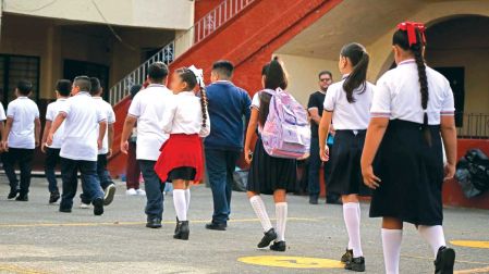 Niños de una escuela de Morelos caminan hacia su salón de clases.