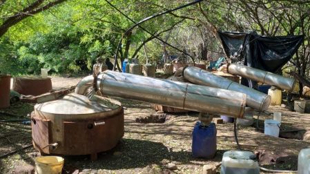 Reactores metálicos y bidones de plástico utilizados para el procesamiento de químicos en un narcolaboratorio clandestino desmantelado.