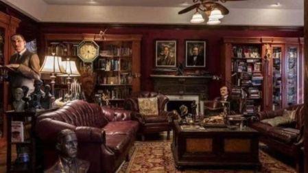Interior de Bleak House de Guillermo del Toro con sofás de cuero, libreros de madera, esculturas y decoración antigua.