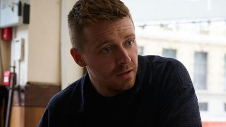Jack Lowden, actor de Slow Horses y posible candidato a James Bond, con cabello corto y suéter oscuro durante una escena.