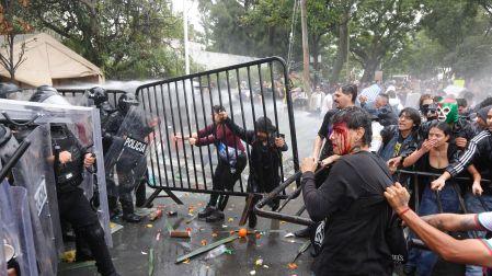 Manifestantes forcejean con policías antimotines y un hombre herido con el rostro ensangrentado durante la marcha por el agua en Jalisco.