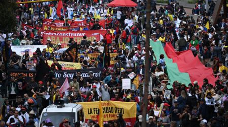 Manifestantes participan en una movilización en Colombia y portan pancartas, banderas y consignas de rechazo a las políticas del Gobierno.