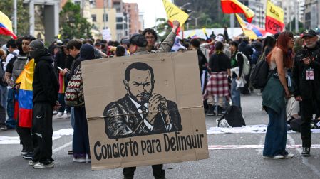 Manifestantes participan en una movilización en Colombia y portan pancartas, banderas y consignas de rechazo a las políticas del Gobierno.