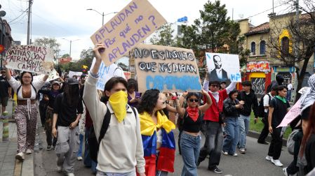 Manifestantes participan en una movilización en Colombia y portan pancartas, banderas y consignas de rechazo a las políticas del Gobierno.
