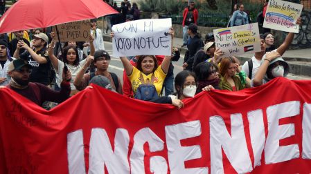 Manifestantes participan en una movilización en Colombia y portan pancartas, banderas y consignas de rechazo a las políticas del Gobierno.