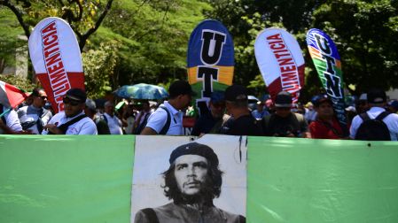 Manifestantes participan en una movilización en Colombia y portan pancartas, banderas y consignas de rechazo a las políticas del Gobierno.