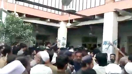 Personas alrededor de la escuela Al-Khairen, en Peshawar, Pakistan, donde murieron 23 personas tras derrumbe.
