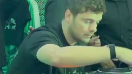 Martin Garrix con camiseta negra manipulando una consola de DJ bajo luces verdes durante su minishow en una taquería de CDMX.