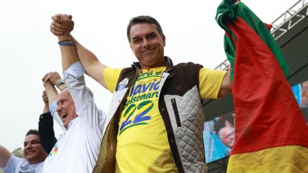 Brazil's right-wing senator and Liberal Party (PL) presidential candidate Flavio Bolsonaro holds the flag of Rio Grande do Sul during a rally at Largo Glenio Peres in Porto Alegre, Brazil, on October 14, 2026, ahead of the presidential election runoff. Bolsonaro heads to a runoff election with leftist President Luiz Inacio Lula da Silva on October 25, buoyed by sweeping gains in Congress, after a shock first-place finish. (Photo by SILVIO AVILA / AFP)