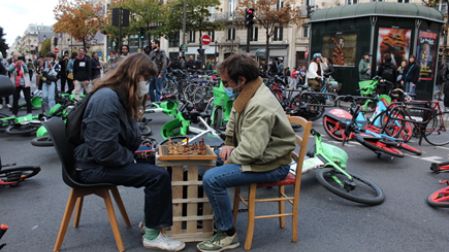 Dos manifestantes juegan ajedrez sobre una barricada en París.