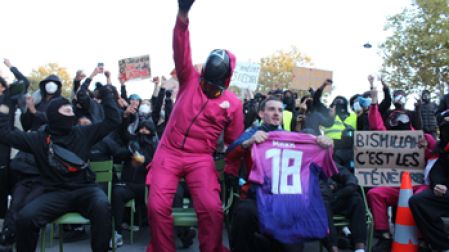Manifestantes sentados en medio de la calle cantan La Marsellesa.