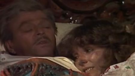 Verónica Castro y Rogelio Guerra acostados juntos en una cama durante una escena de Los ricos también lloran.