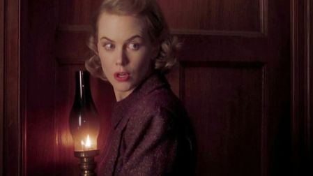 Nicole Kidman como Grace Stewart sostiene una lámpara de aceite encendida en una escena oscura de Los otros.