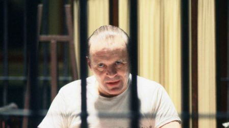 Anthony Hopkins como Hannibal Lecter, vestido de blanco y detrás de los barrotes de su celda en El silencio de los inocentes.