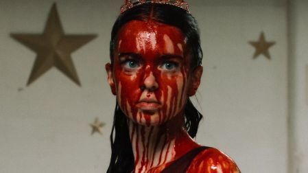 Carrie White con tiara, cabello oscuro y rostro cubierto de sangre durante el baile escolar en la serie Carrie de Prime Video.